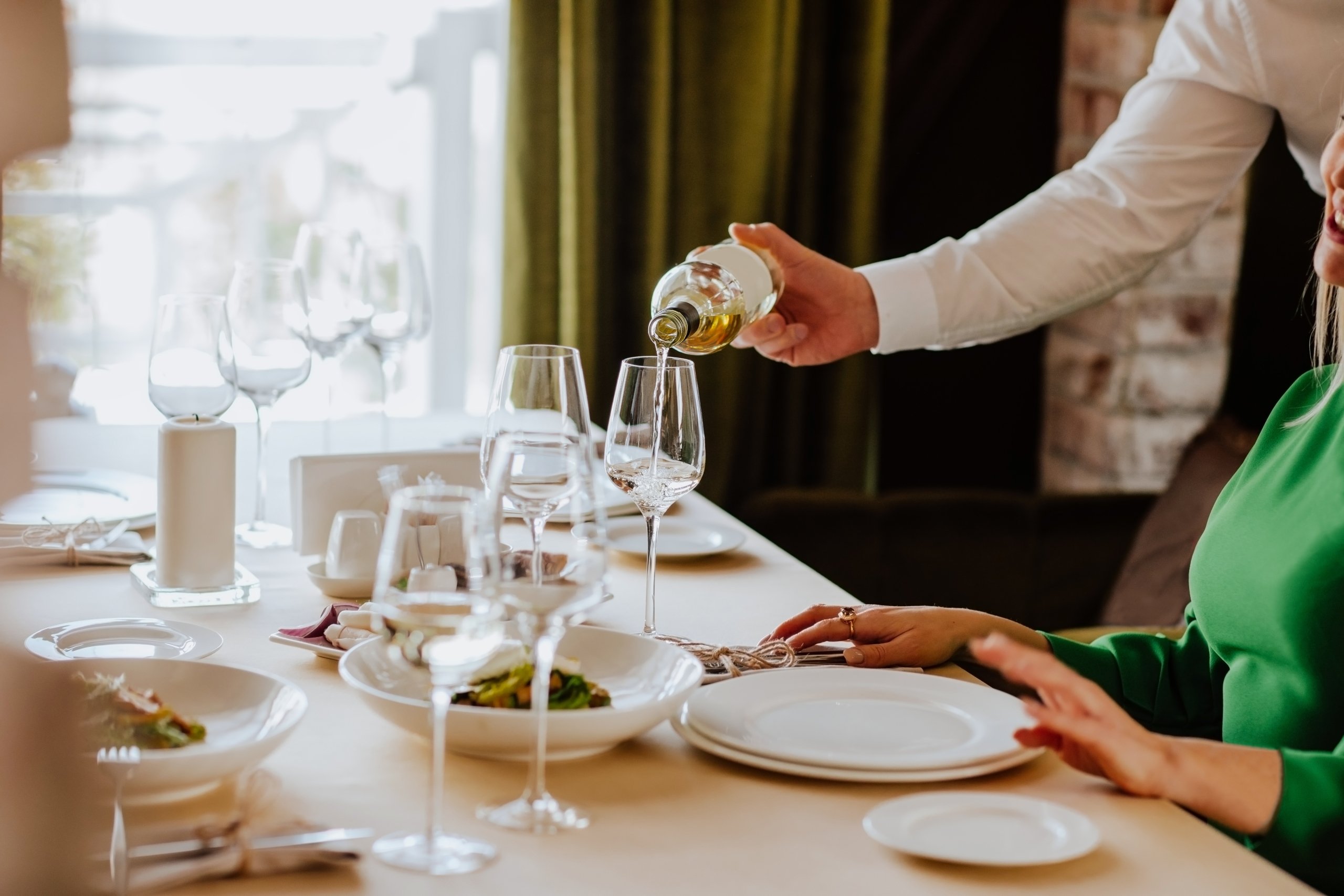 waiter pouring wine into a glass